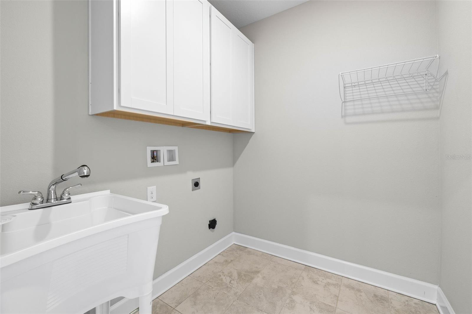 Laundry room with additional cabinetry and sink.