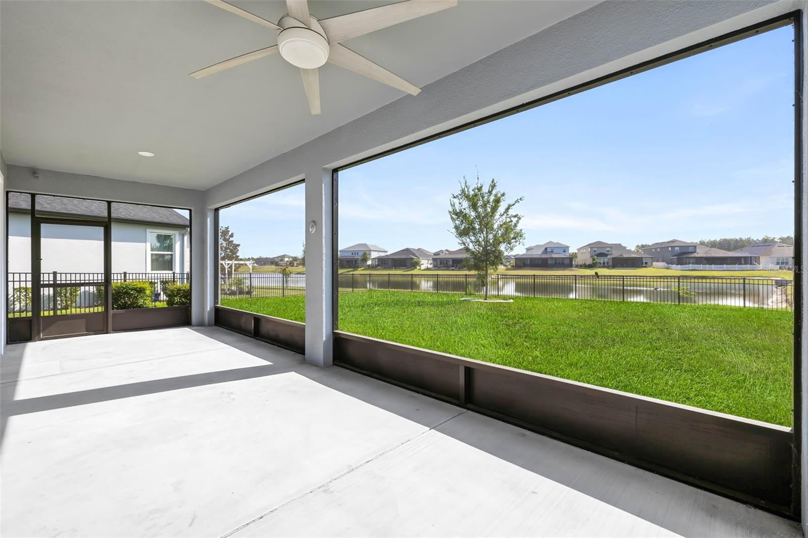 Extended concrete lanai, screened in with expansive view of the pond.