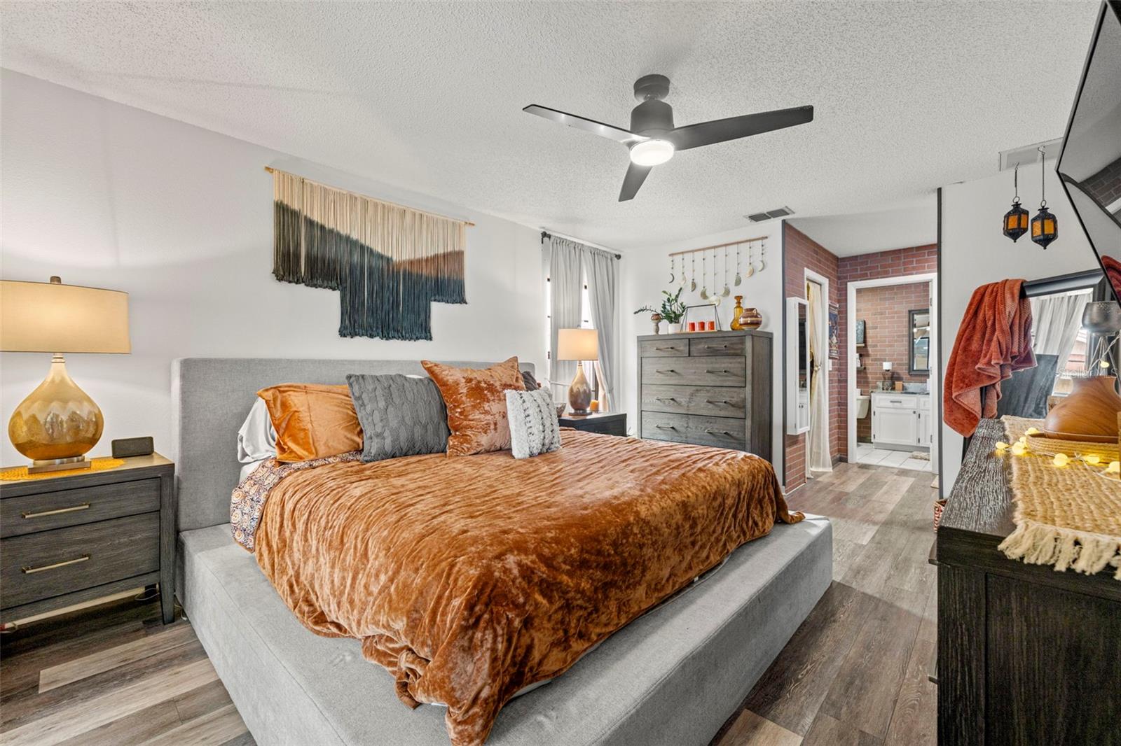 Primary retreat!  This room is magical!  Featuring sliding glass doors to the lanai and pool, ceiling fan, luxury vinyl flooring, a walk-in closet, dual vanities with sinks, a walk-in closet, walk-in shower and tons of storage!