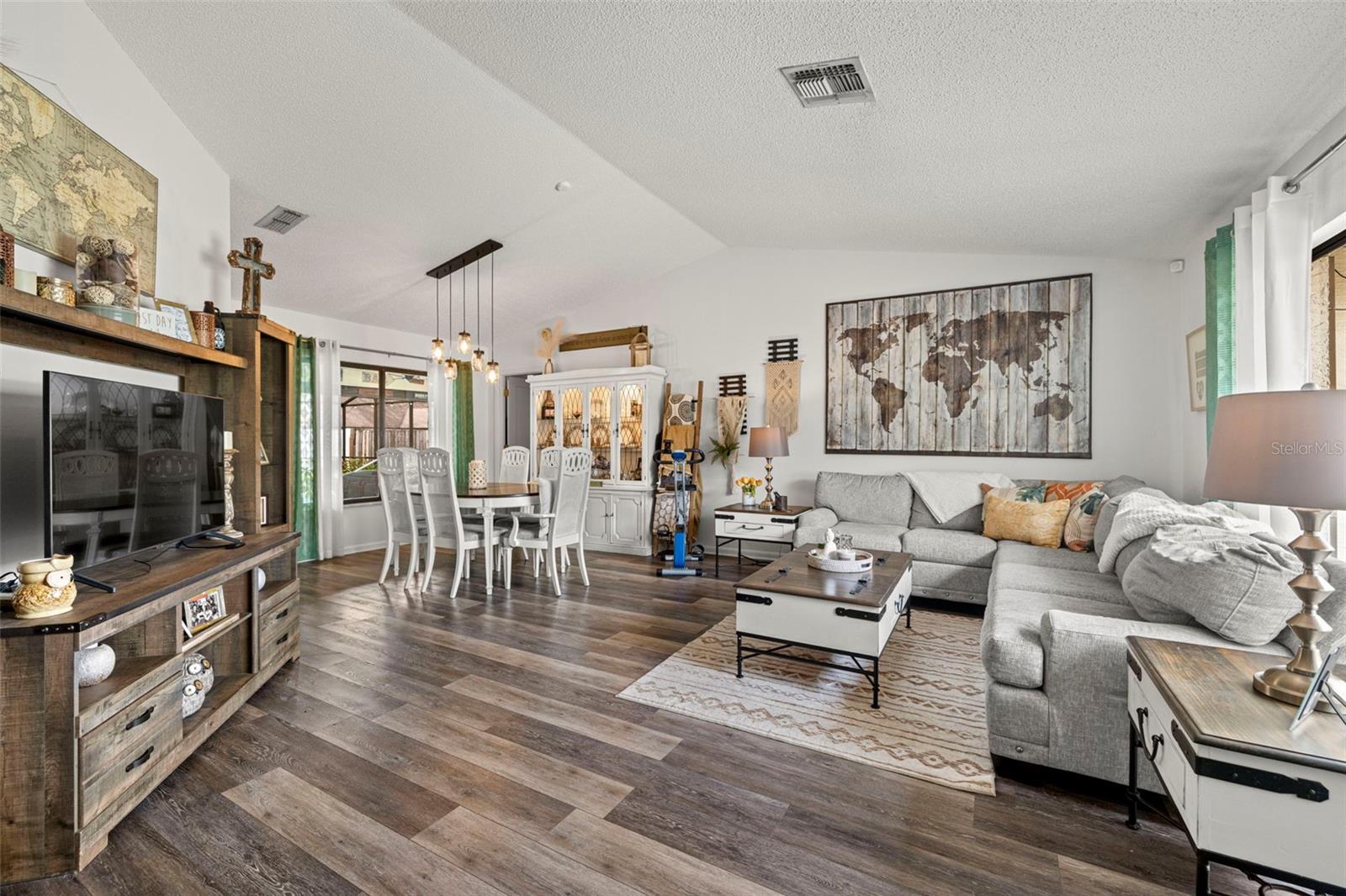 View from entry way toward Living / Dining Room combination! Updated luxury vinyl flooring is throughout the home along with on-trend, updated lighting fixtures.