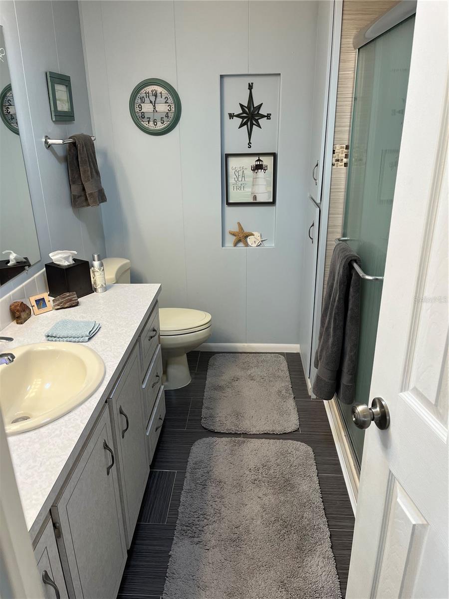 Main bathroom with walk-in shower and linen closet.