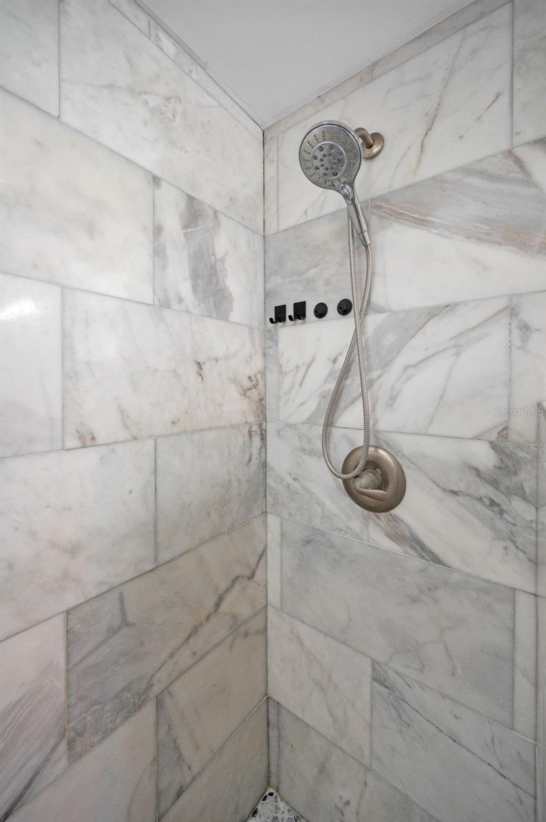 2020 primary bathroom features double vanity, and glass enclosed tile shower.