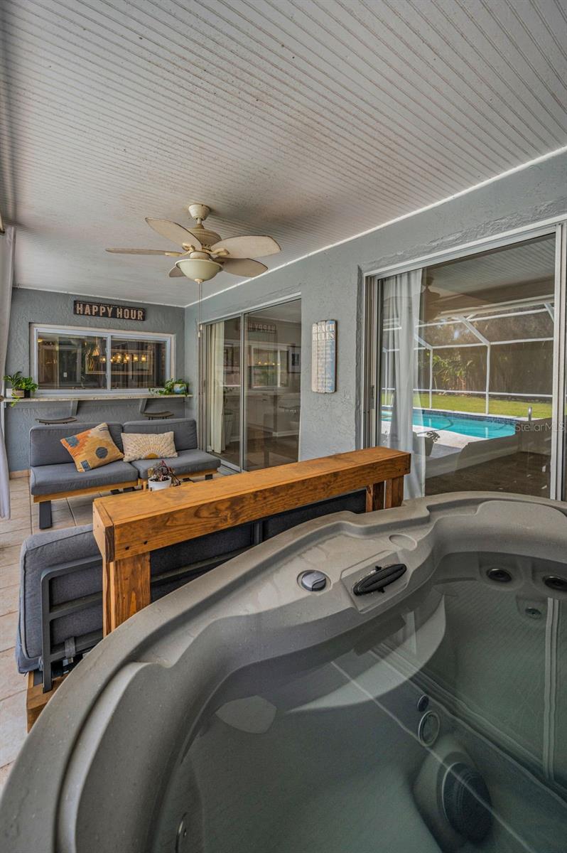Sheltered lanai accommodates a conversation area and a hot tub.