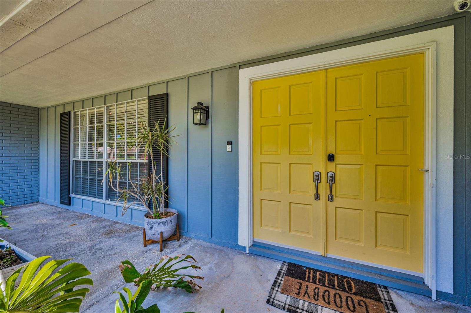 Double wooden front doors with keypad for easy and secure entry.