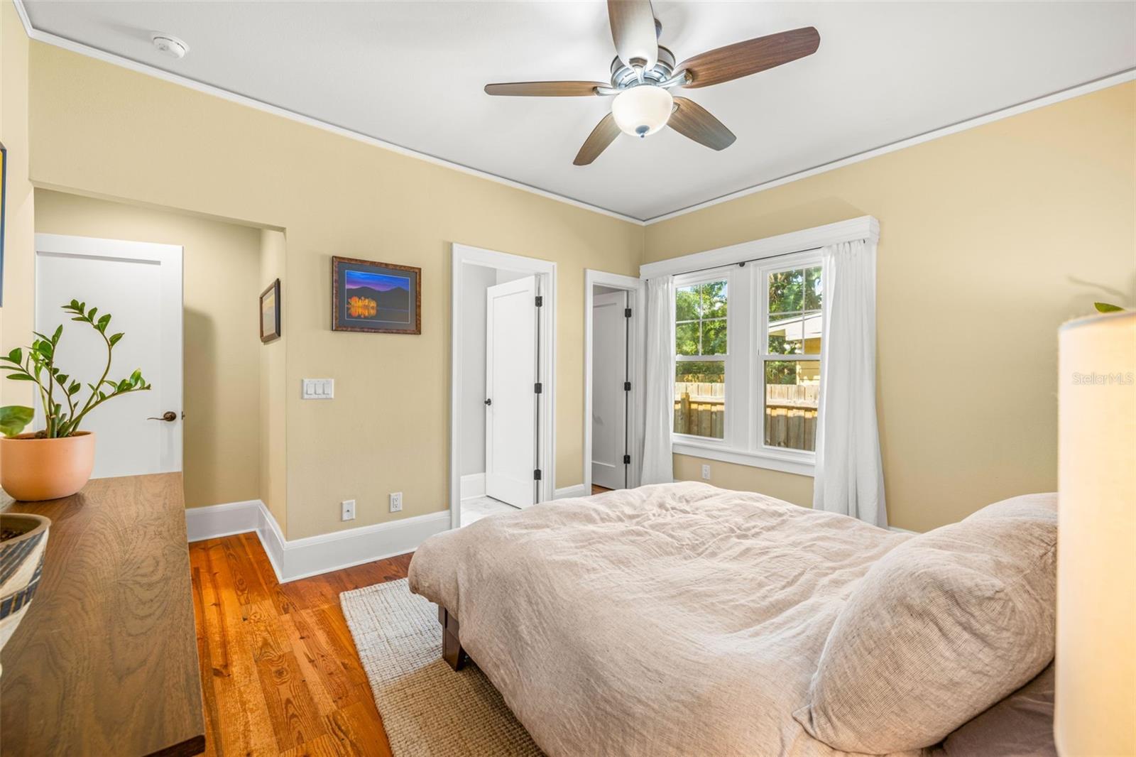 A walk-in closet next to the window and entry to the primary bathroom beside it.