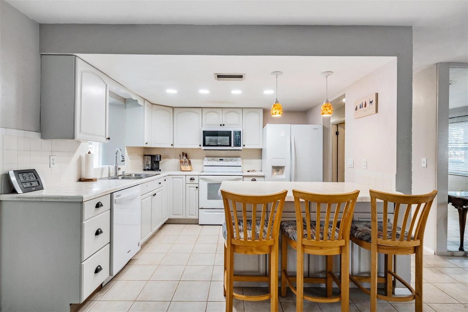 The comfortable kitchen features an abundance of solid wood cabinetry, providing ample storage and a warm, inviting atmosphere.