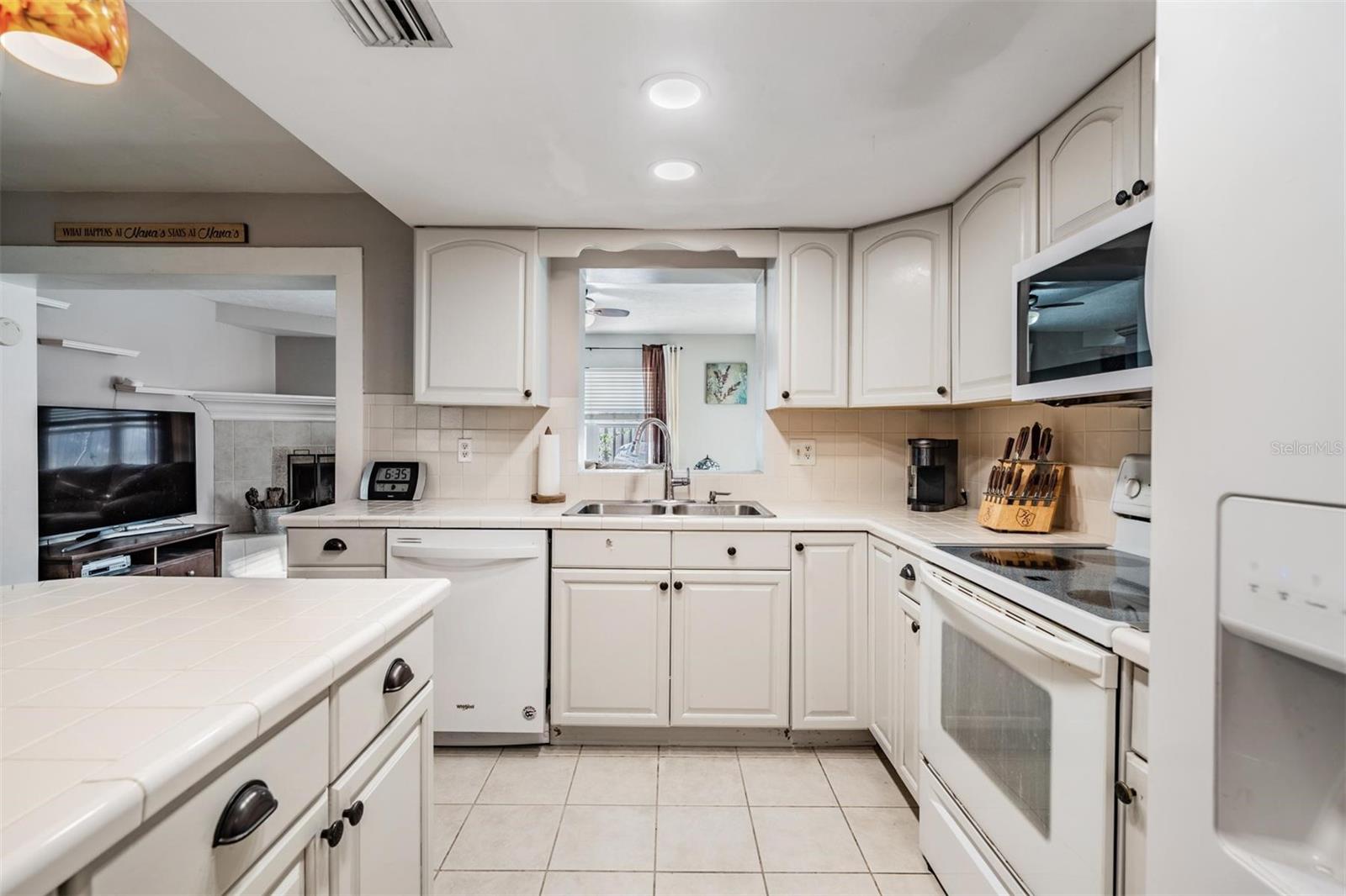 A convenient window pass-through from the kitchen to the den makes serving food and drinks a breeze.