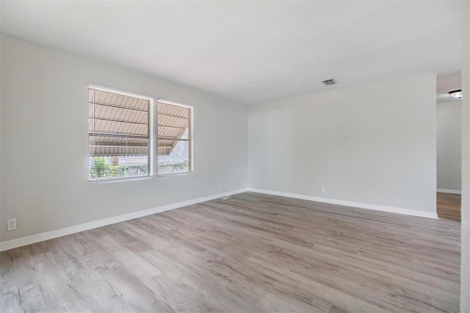 Living Room.  NEW LUX VINYL PLANK FLOORS. NO POPCORN CEILING.  DRYWALL ON WALLS.
