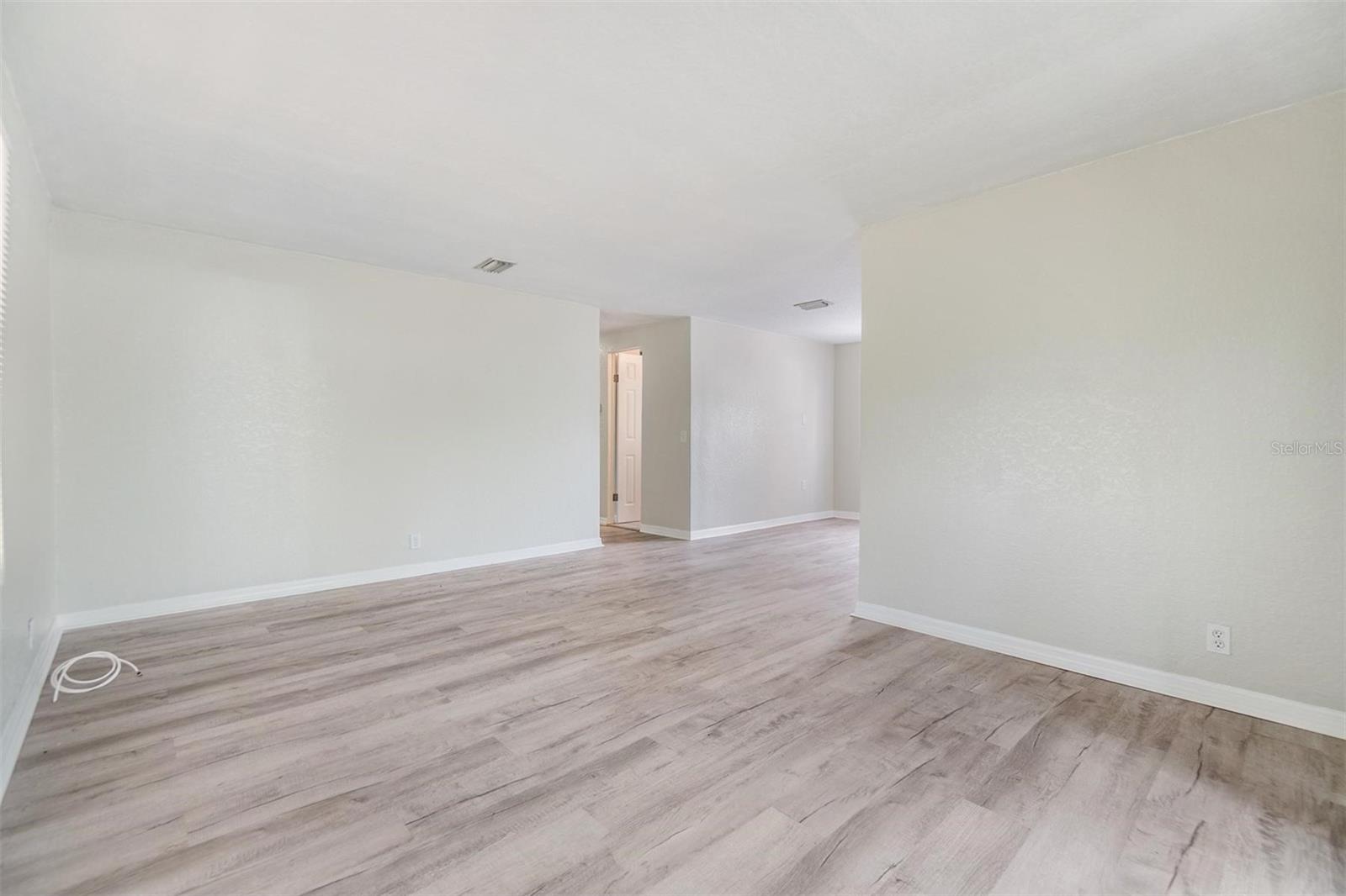 Living Room.  NEW LUX VINYL PLANK FLOORS. NO POPCORN CEILING.  DRYWALL ON WALLS.