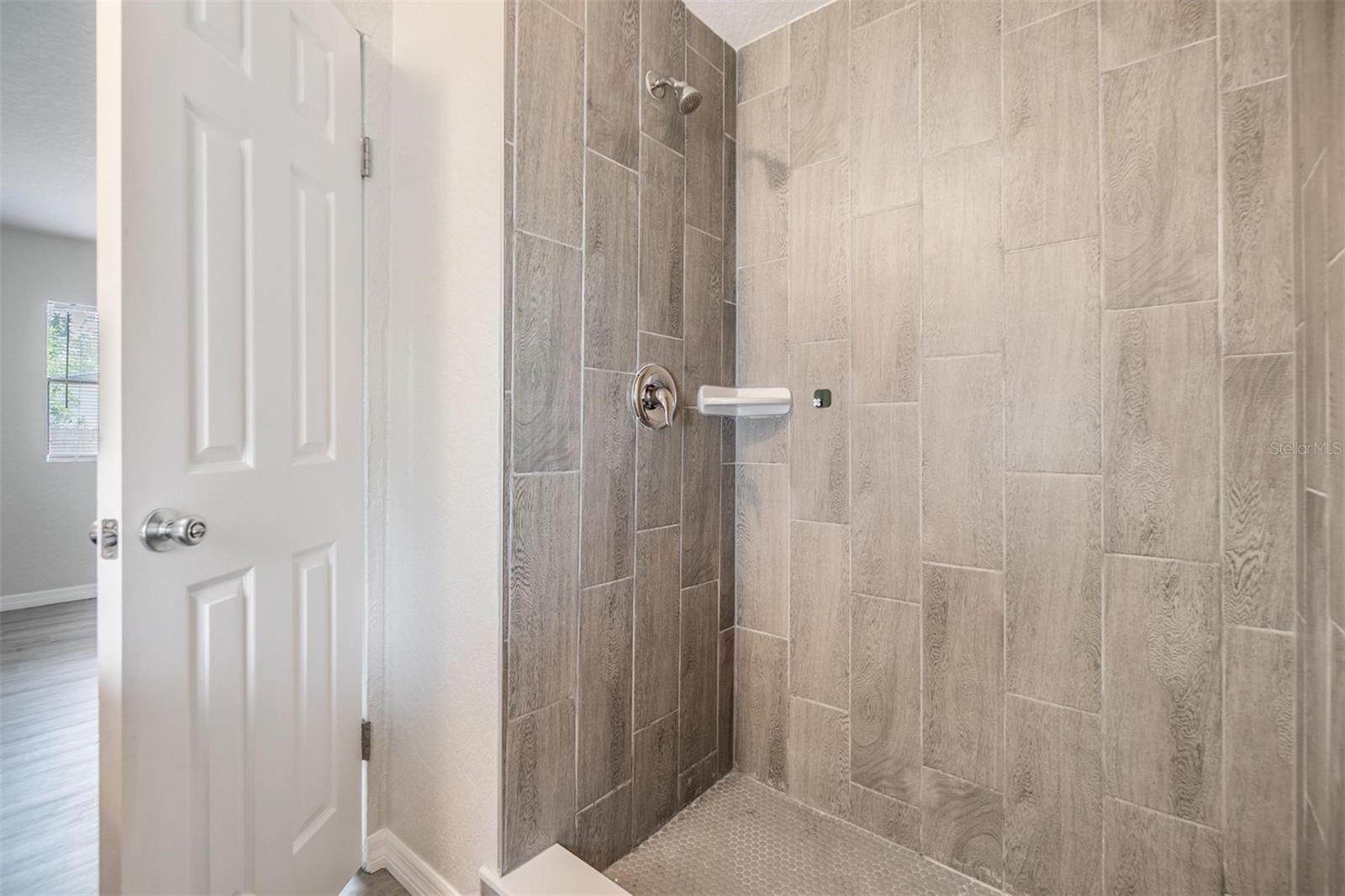 Primary bedroom shower.  NEW LUX VINYL PLANK FLOORS. NO POPCORN CEILING.  DRYWALL ON WALLS.