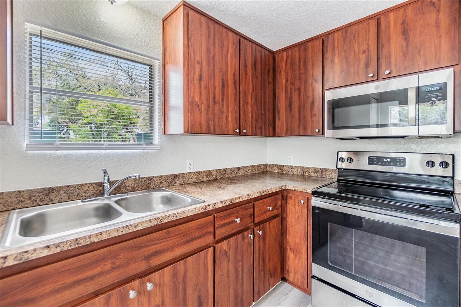 Double sink in kitchen with window to road frontage. Stainless Steel appliances. NEW LUX VINYL PLANK FLOORS. NO POPCORN CEILING.  DRYWALL ON WALLS.