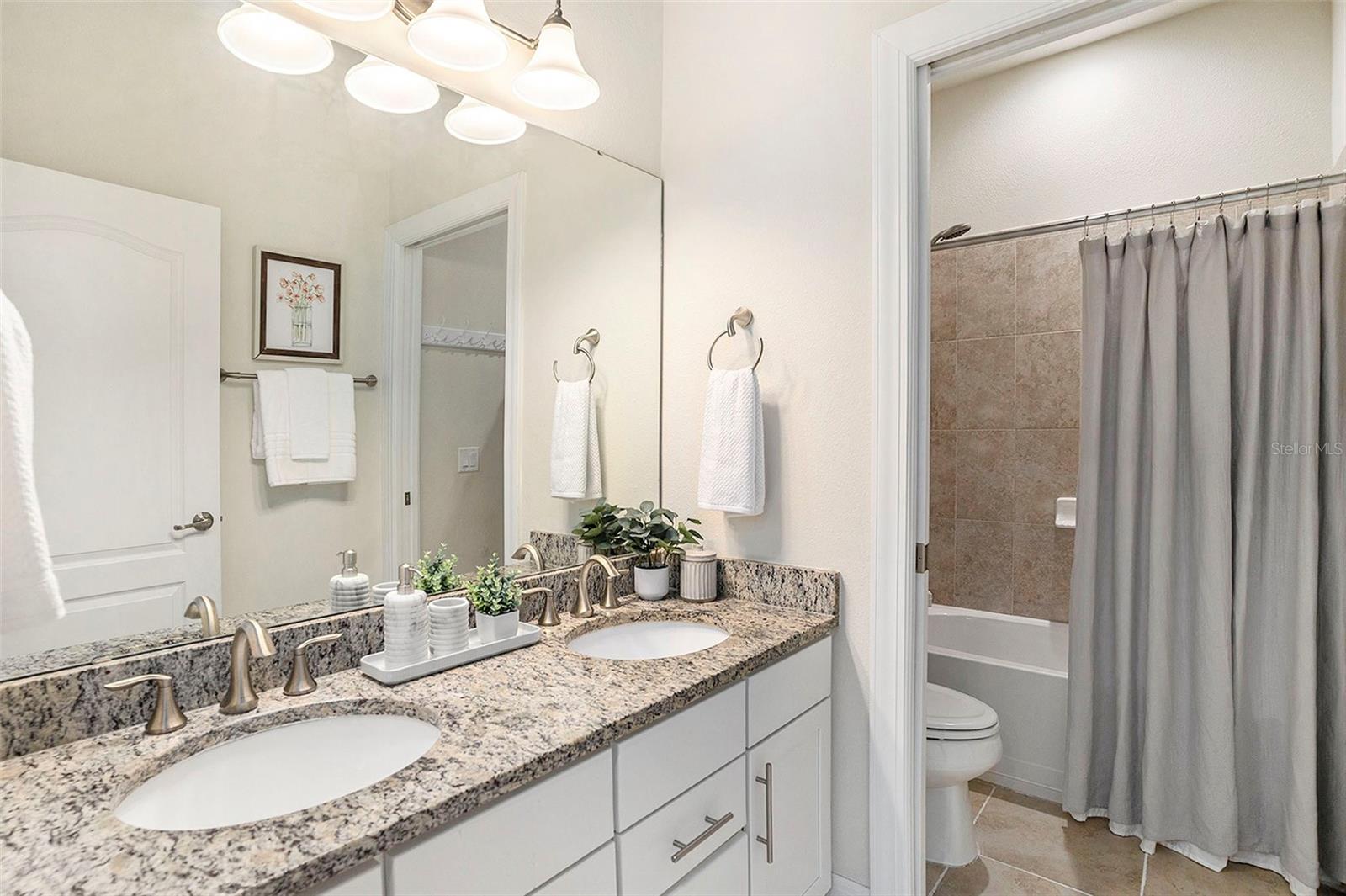Bathroom #2 with dual sink vanity and separate water closet with bath/shower combination
