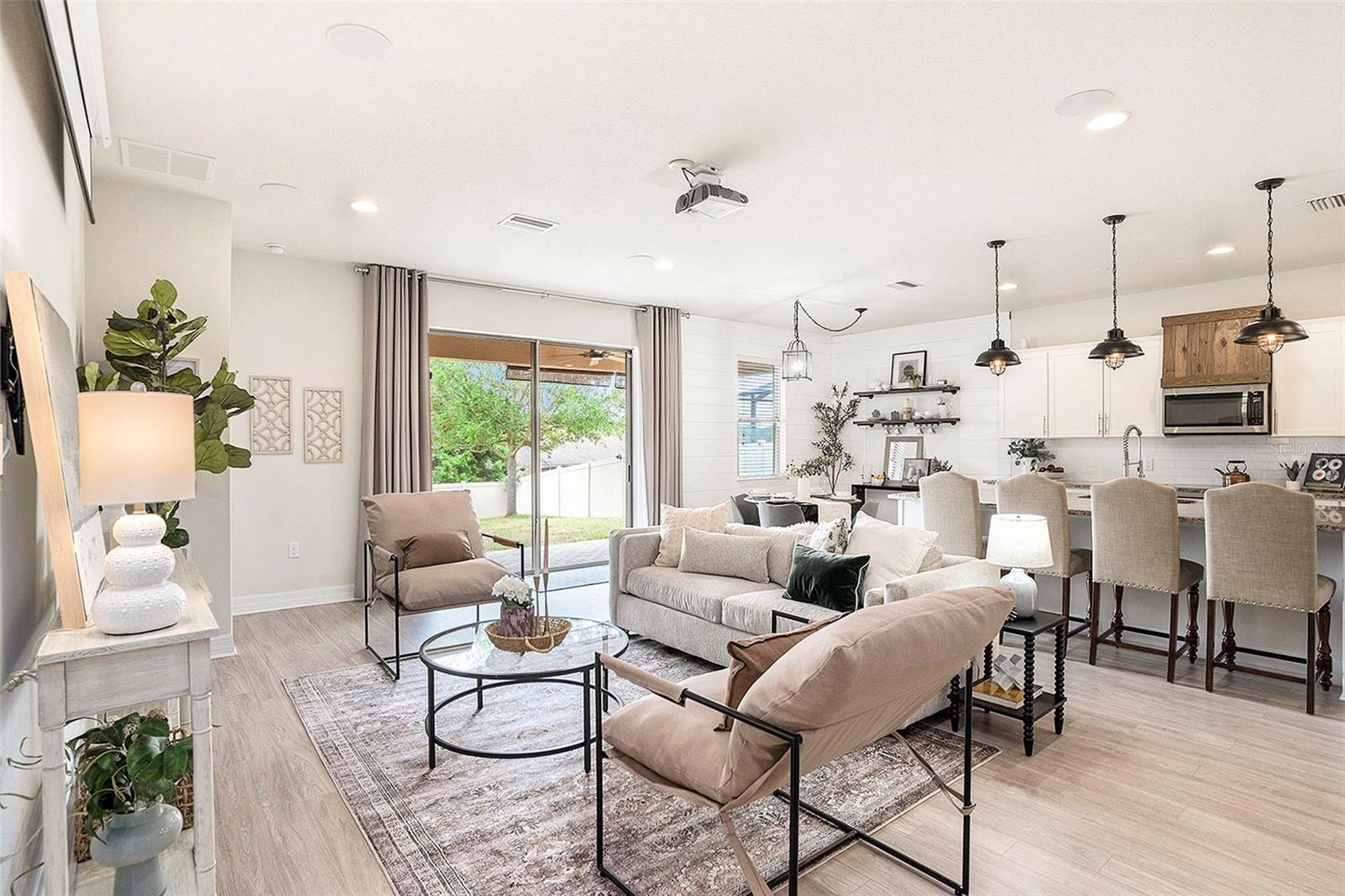 Pristine Great room with extra large space for entertaining, combination room with kitchen that includes extra large entertainment bar, pantry, sliding doors to let the Florida light inside, and even a theatre quality remote screen and home cinema projector (both convey), and eat in kitchen too!