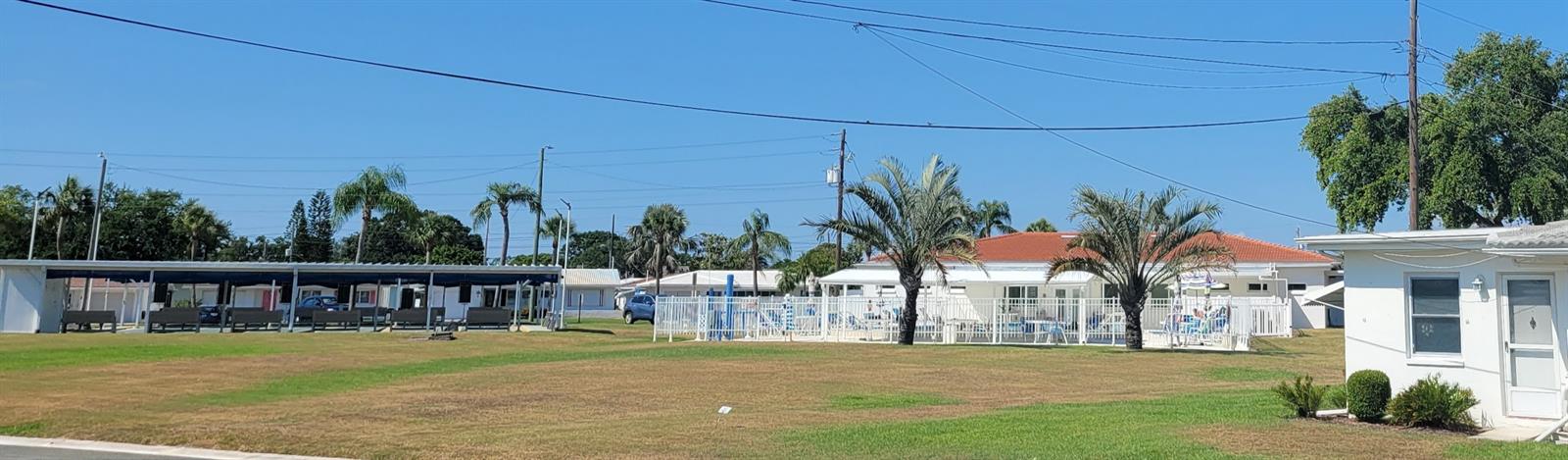 The view from the porch shows the proximity to the Unit 3 pool, shuffleboard court, and clubhouse.