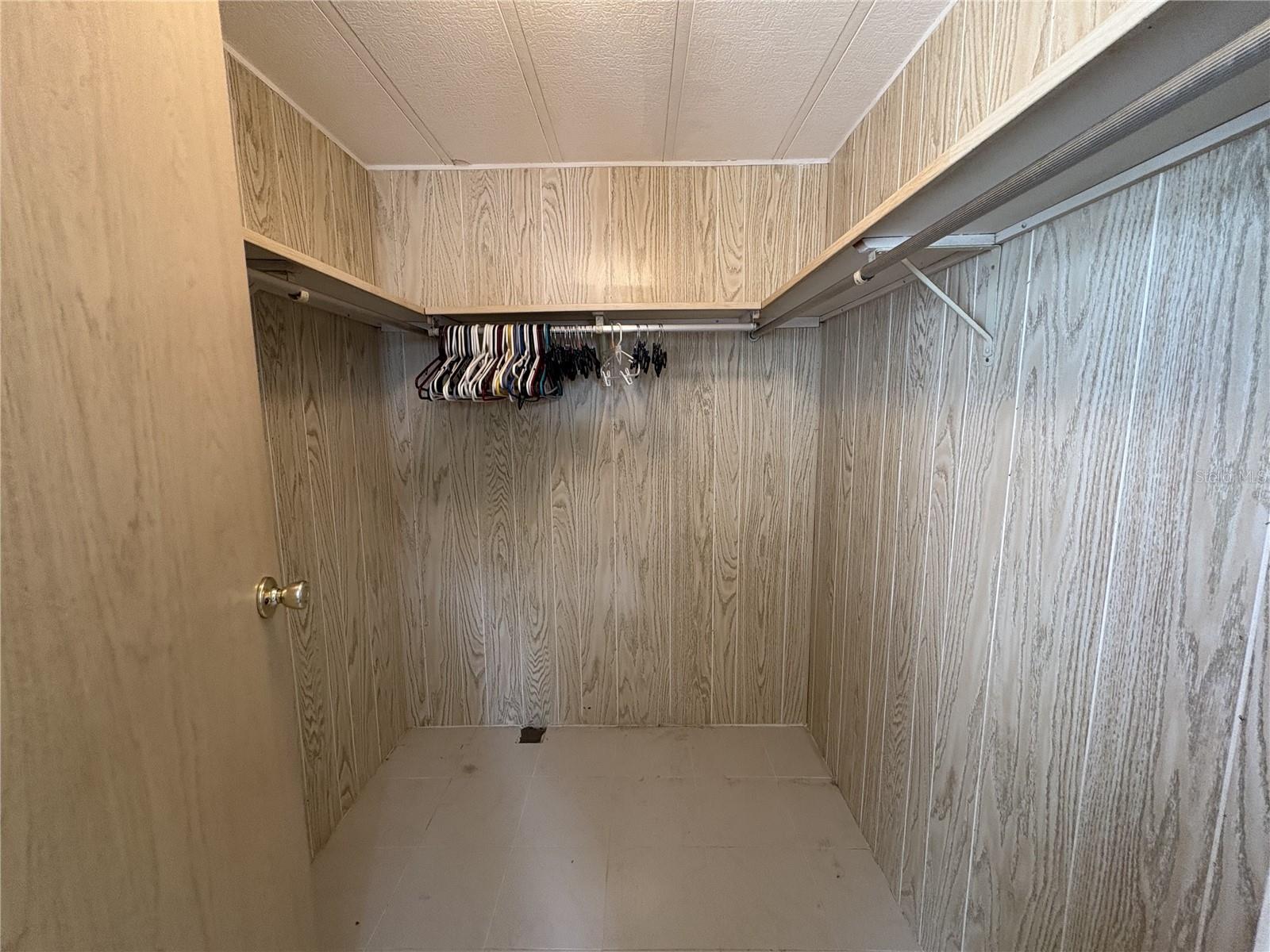 walk in closet with porcelain floors
