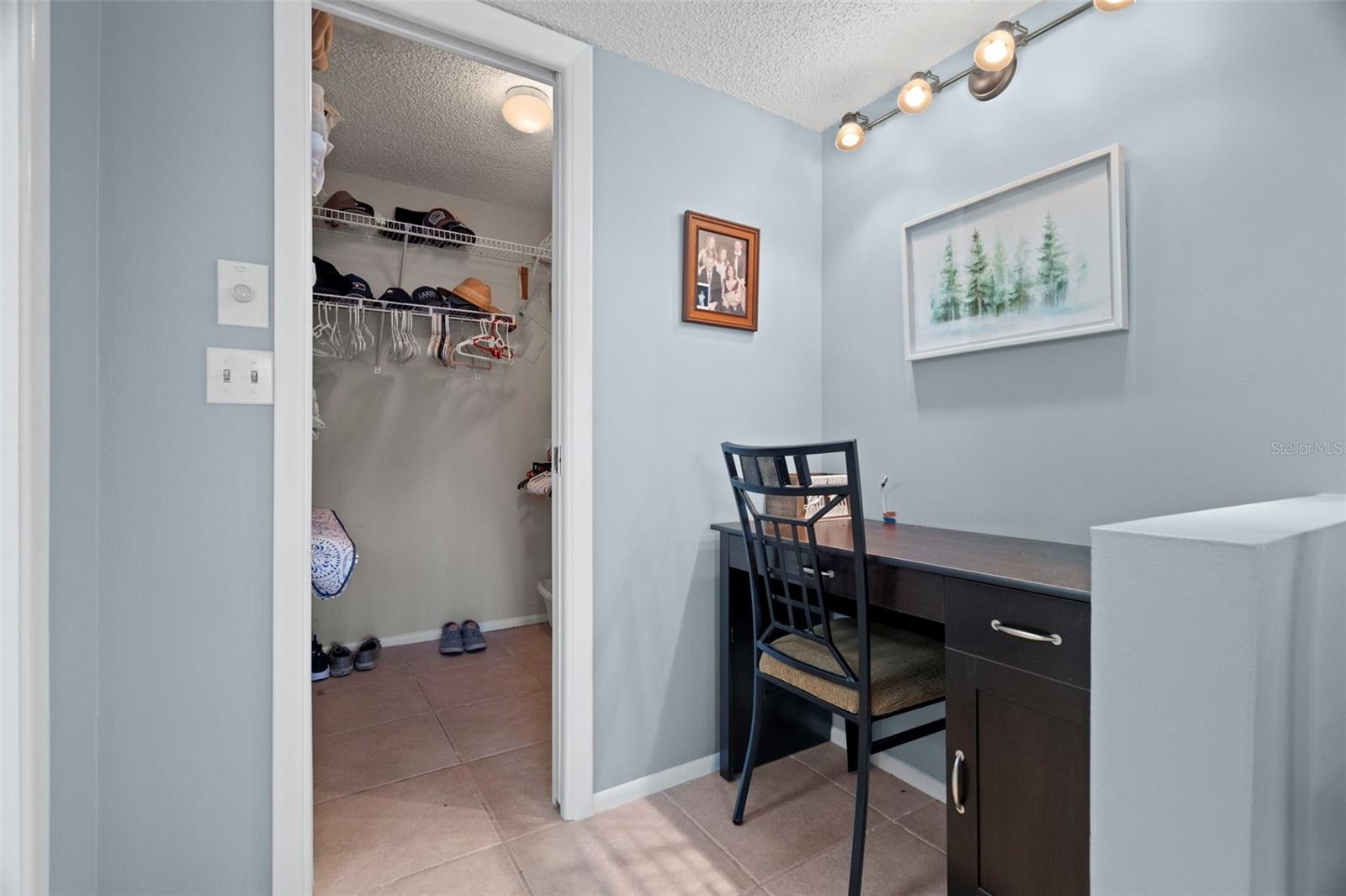 Desk area in primary bedroom with walk-in closet