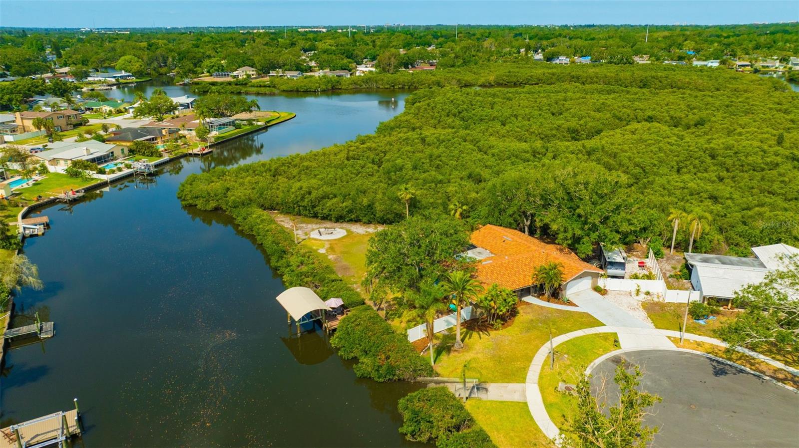 Aerial view of your private Clearwater retreat—complete with boat lift, private ramp, pool, RV pad, and lush mangrove surroundings along Allens Creek. Waterfront living starts here!