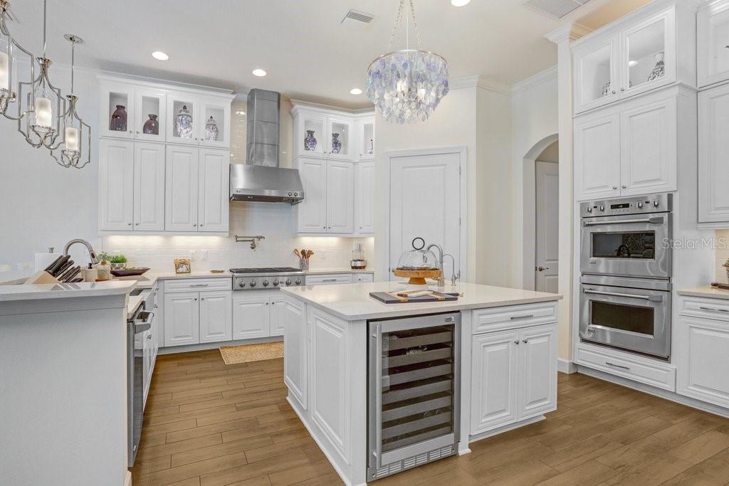 GE Monogram double ovens and wine fridge in island.