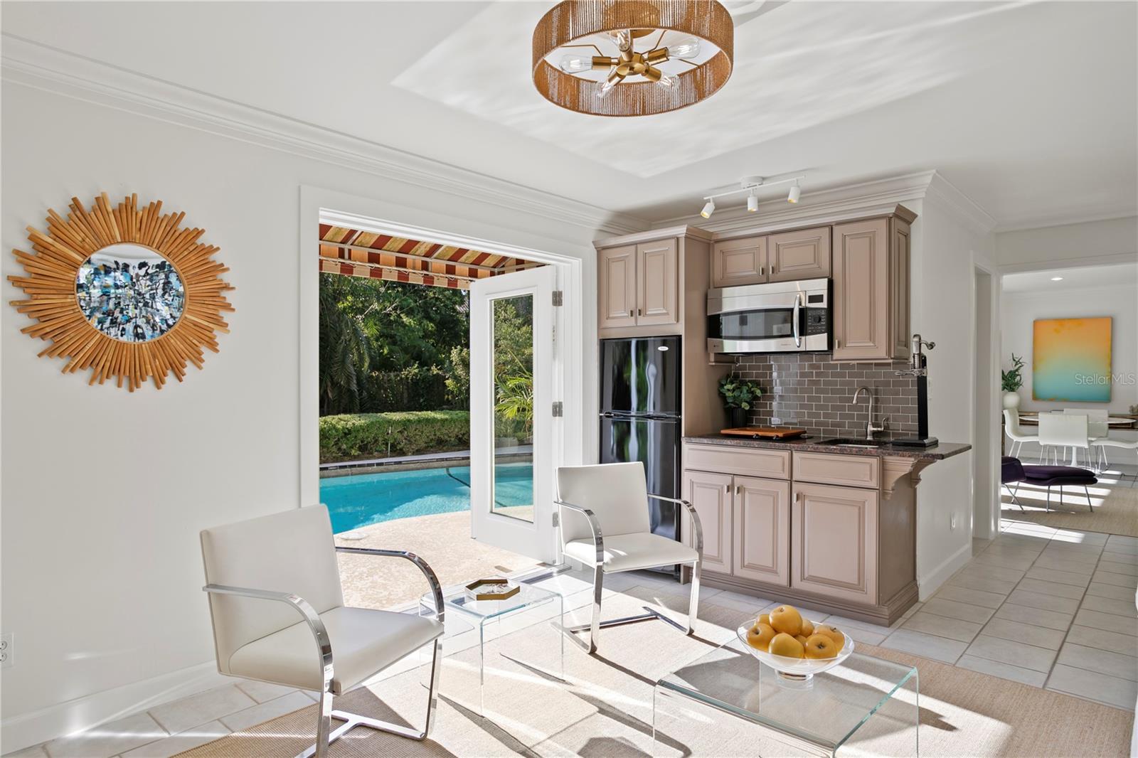 This room features a built-in wet bar—just right for mixing cocktails, and opens to the backyard for enjoying sunny Florida afternoons by the pool.