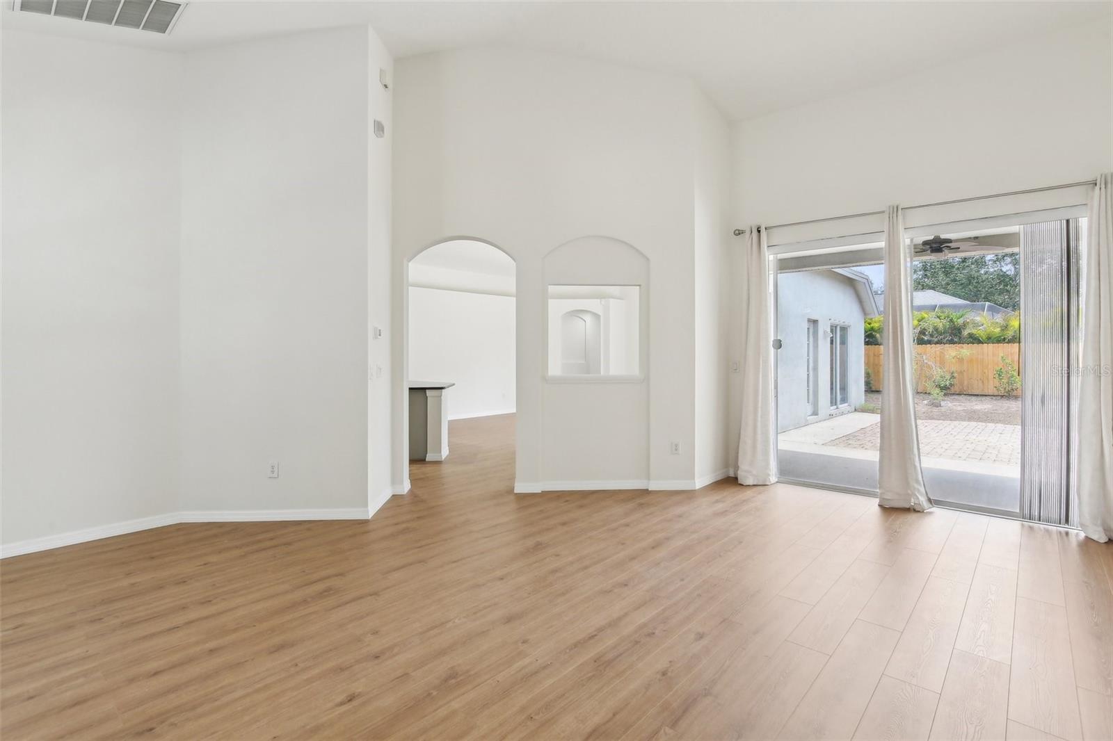 LOOKING FROM FRONT DOOR, ARCHED ENTRY TO KITCHEN, DINETTE AND FAMILY ROOM