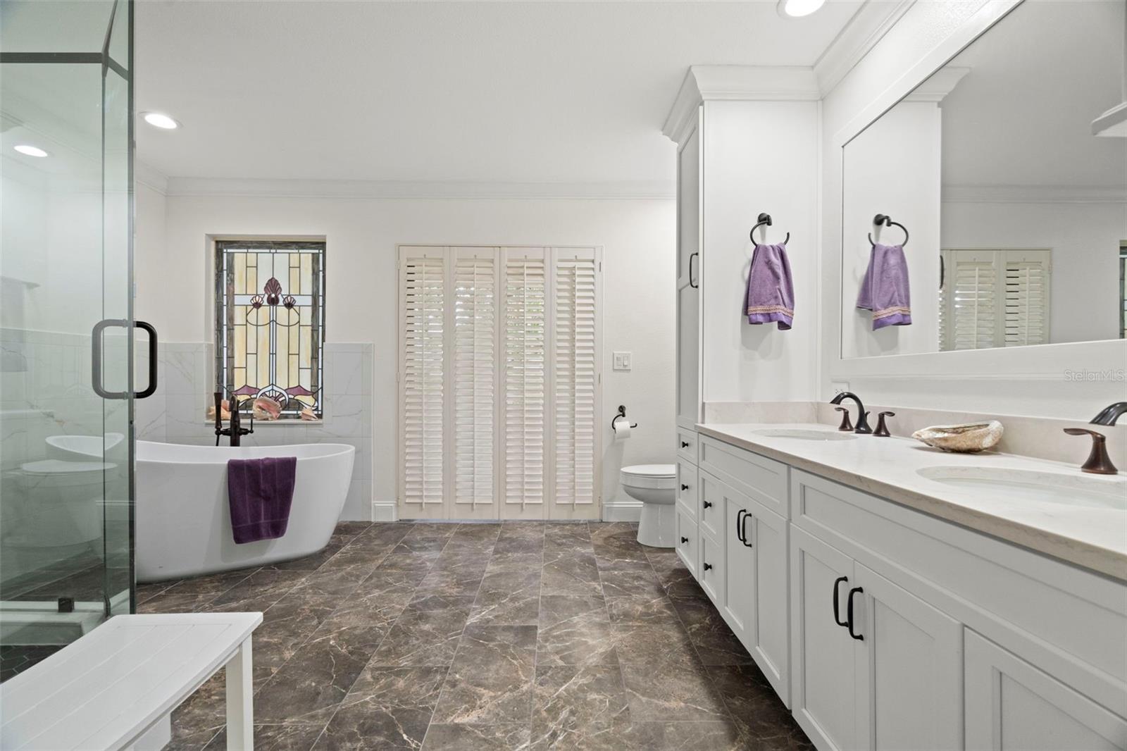 Newly remodeled en suite with modern freestanding tub and extra large walk-in shower with built-in seat.