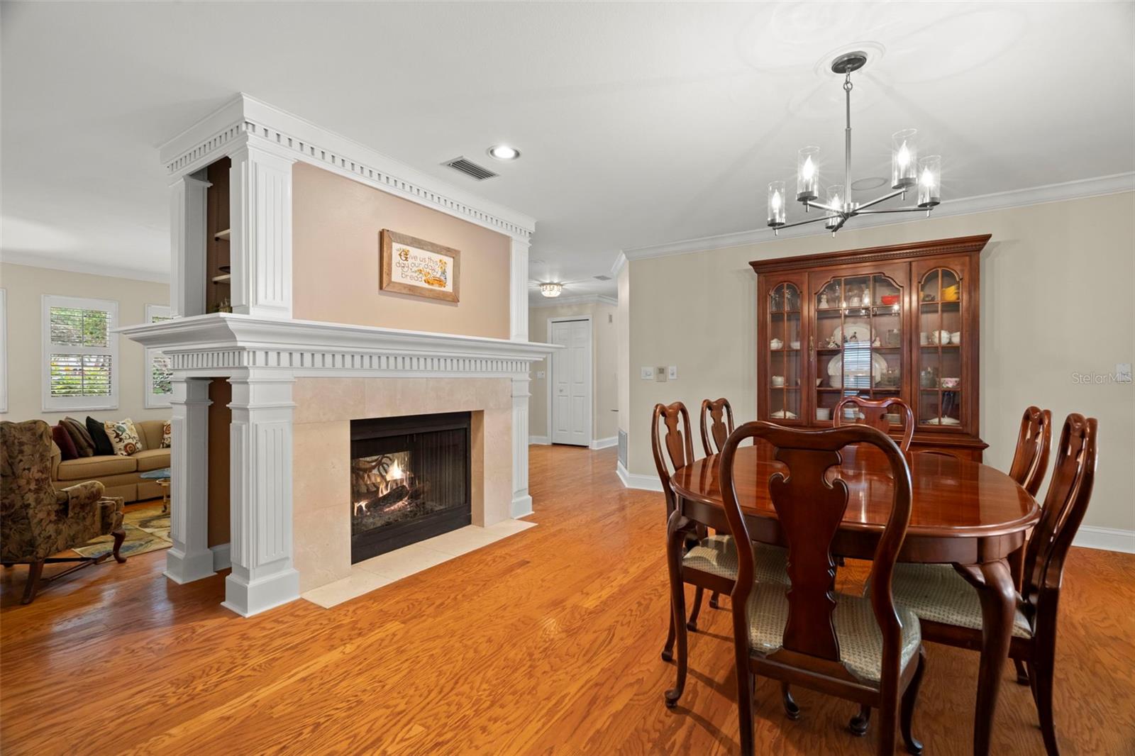 Dining room view with living room on other side of fireplace; sliders to patio on right.
