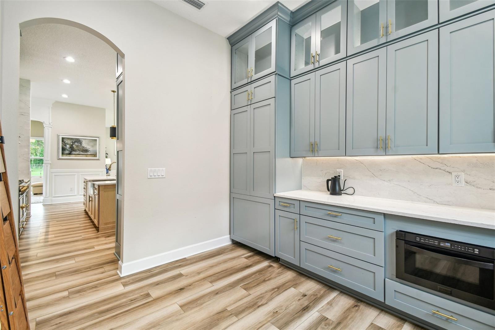 Butler's pantry with sink, microwave, mini frig and paneled refrigerator