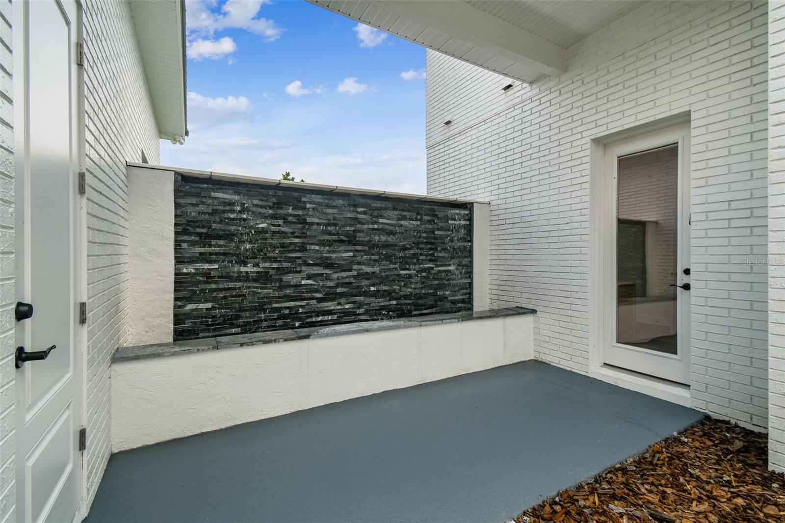 Breezeway with waterfall between Mudroom/Laundry room and Garage