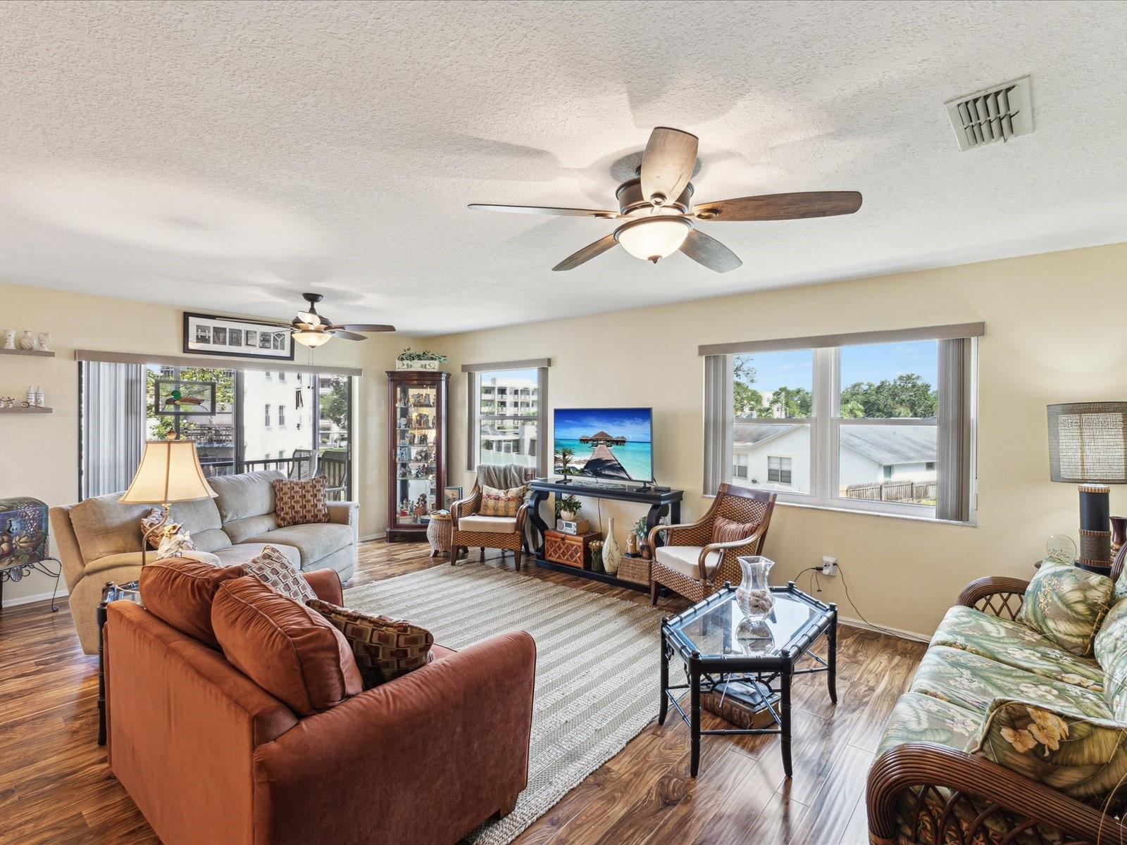 Large living room with engineered wood flooring, impact windows/door and lots of natural light