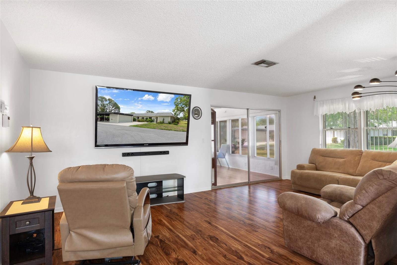 Living Room with Laminate Flooring and Sliders to Florida Room