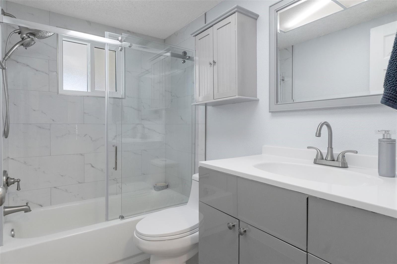 Bath 2 with NEW Vanity and Tiled tub with NEW Glass Doors
