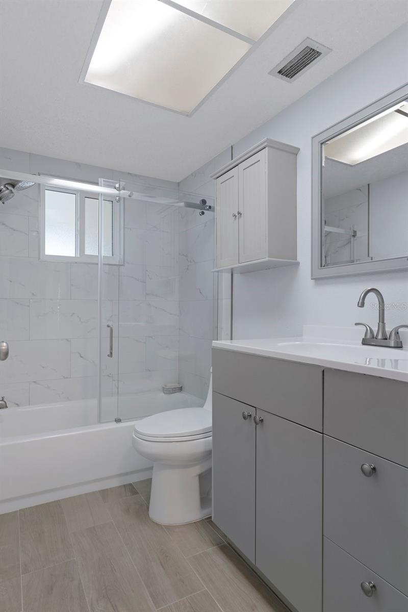 Bath 2 with NEW Vanity and Tiled tub with NEW Glass Doors