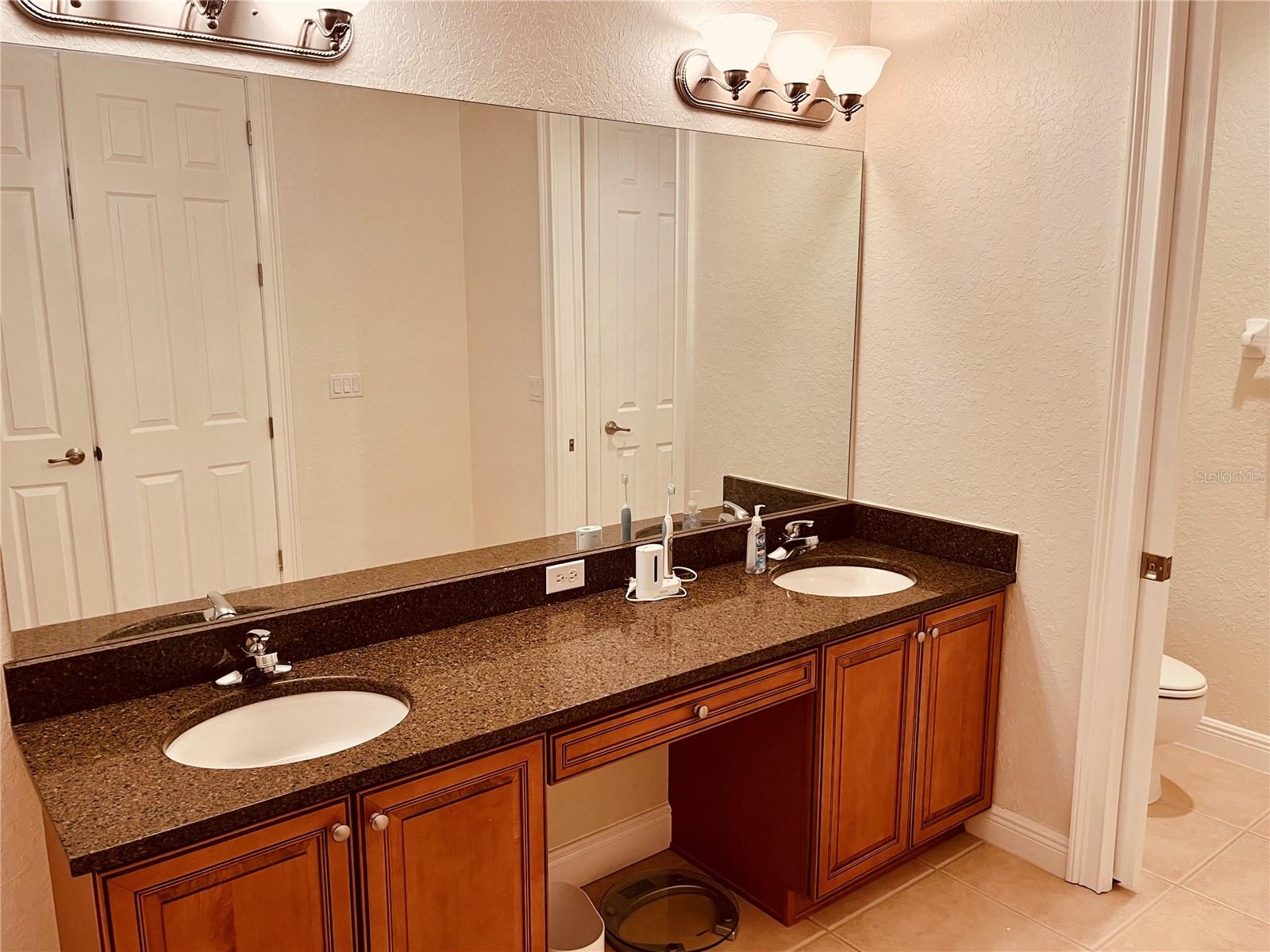 Double sinks, granite and maple cabinets matching the kitchen