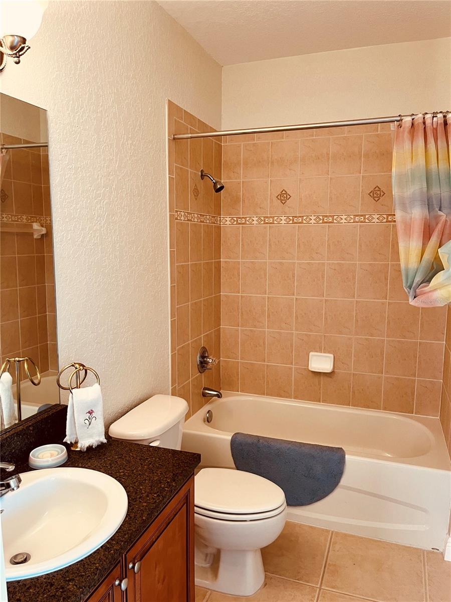 Guest bath with same granit and wood cabinets