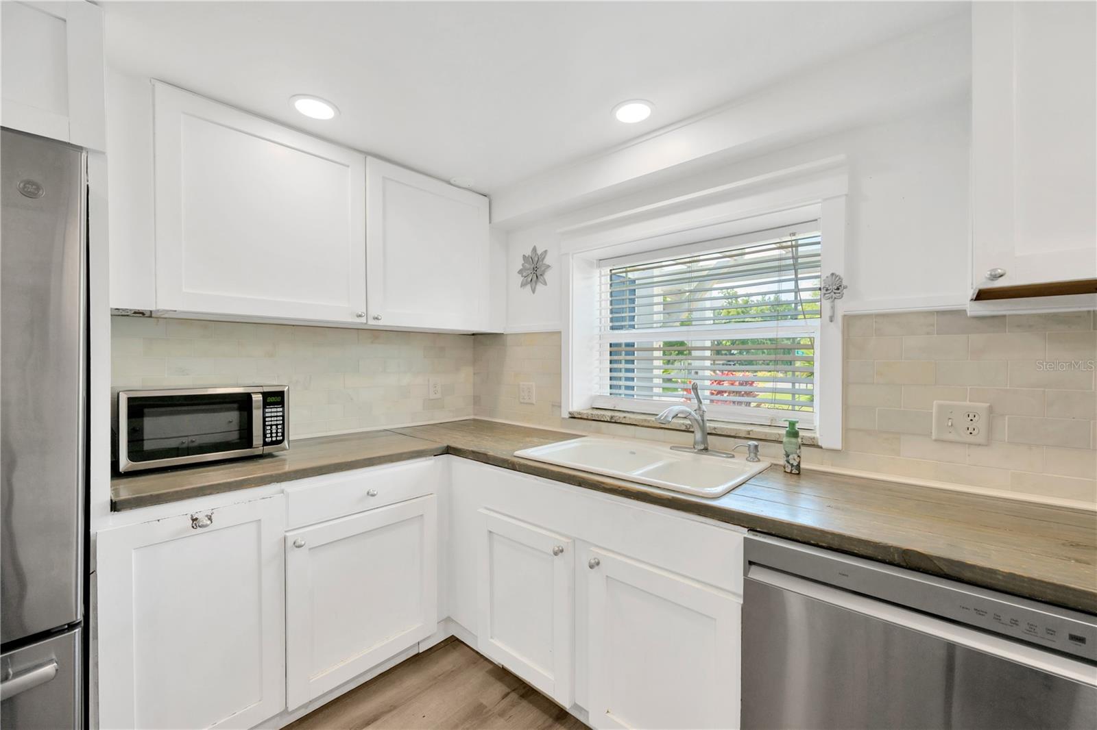 Durable pine countertops, solid wood white cabinetry and a stunning cast iron porcelain farmhouse sink.