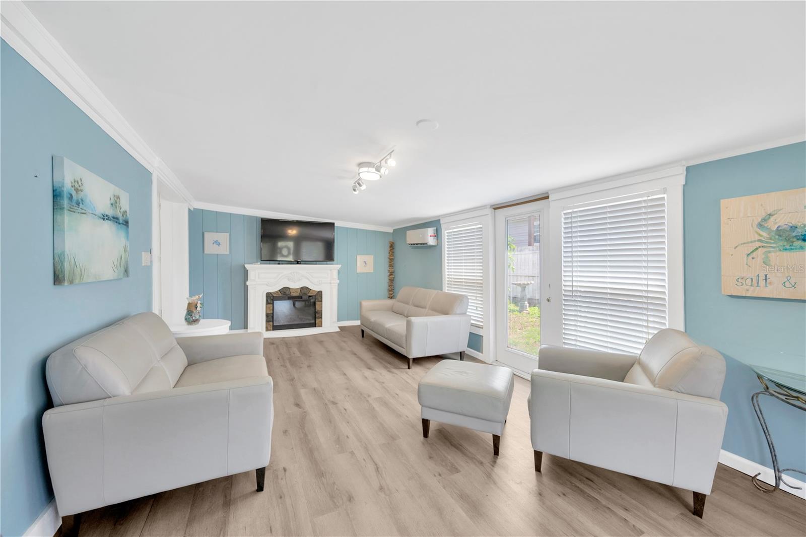 Step inside to a warm and welcoming 12' x 23' family room, featuring NuCore cork-backed waterproof flooring, a stylish light fixture, shiplap accent wall, and a convenient exterior door that opens to a serene side garden.