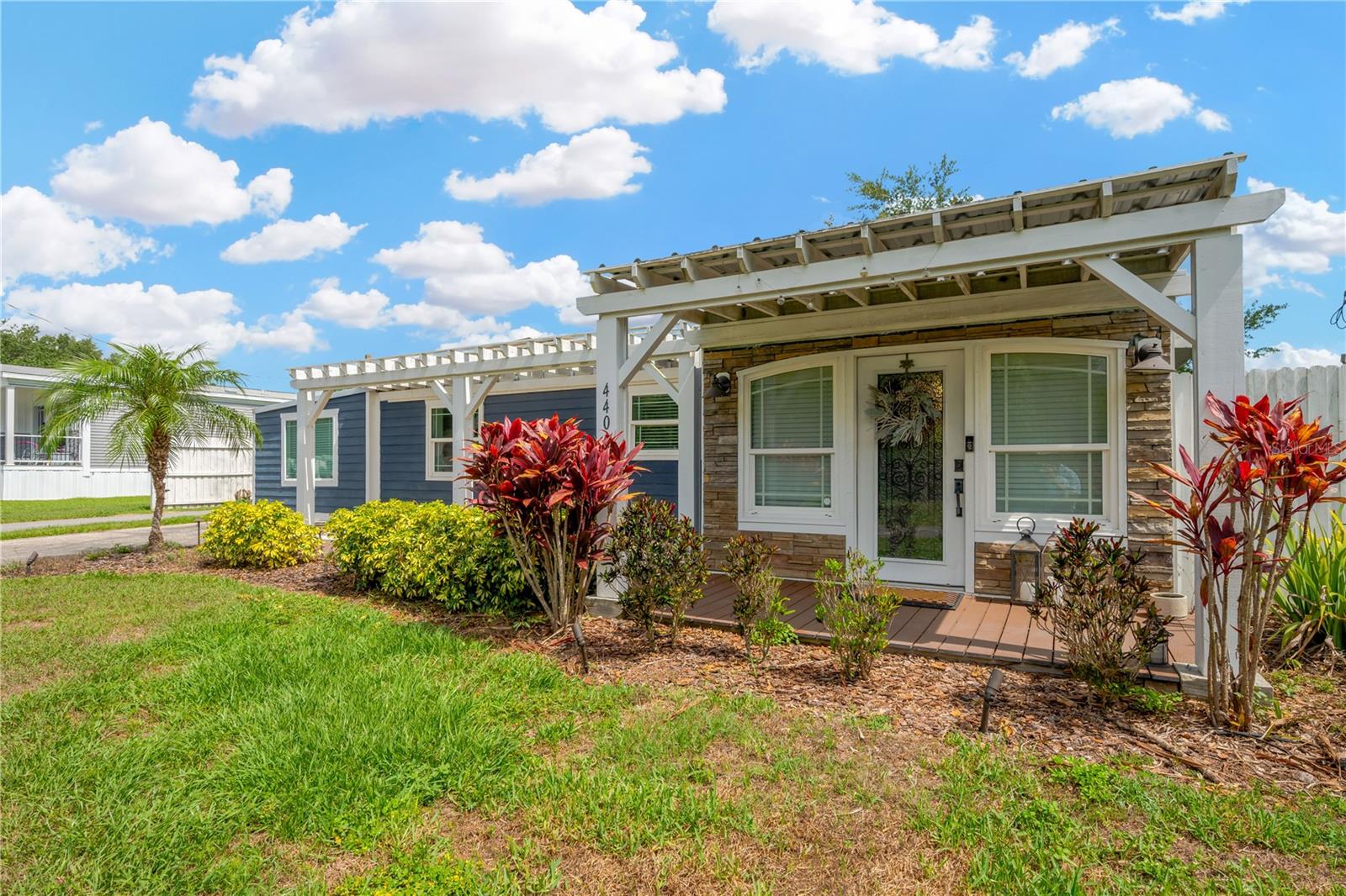 Florida friendly landscaping and the durable composite deck pathway lead you to the front porch and leaded glass front door.