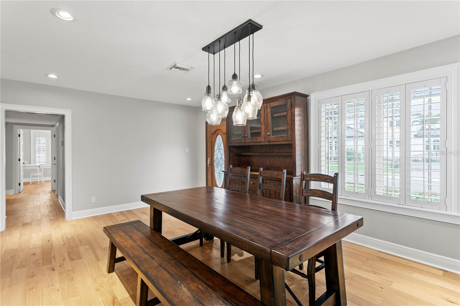 This hallway off of the entrance leads to a spacious primary suite and secondary bedrooms.