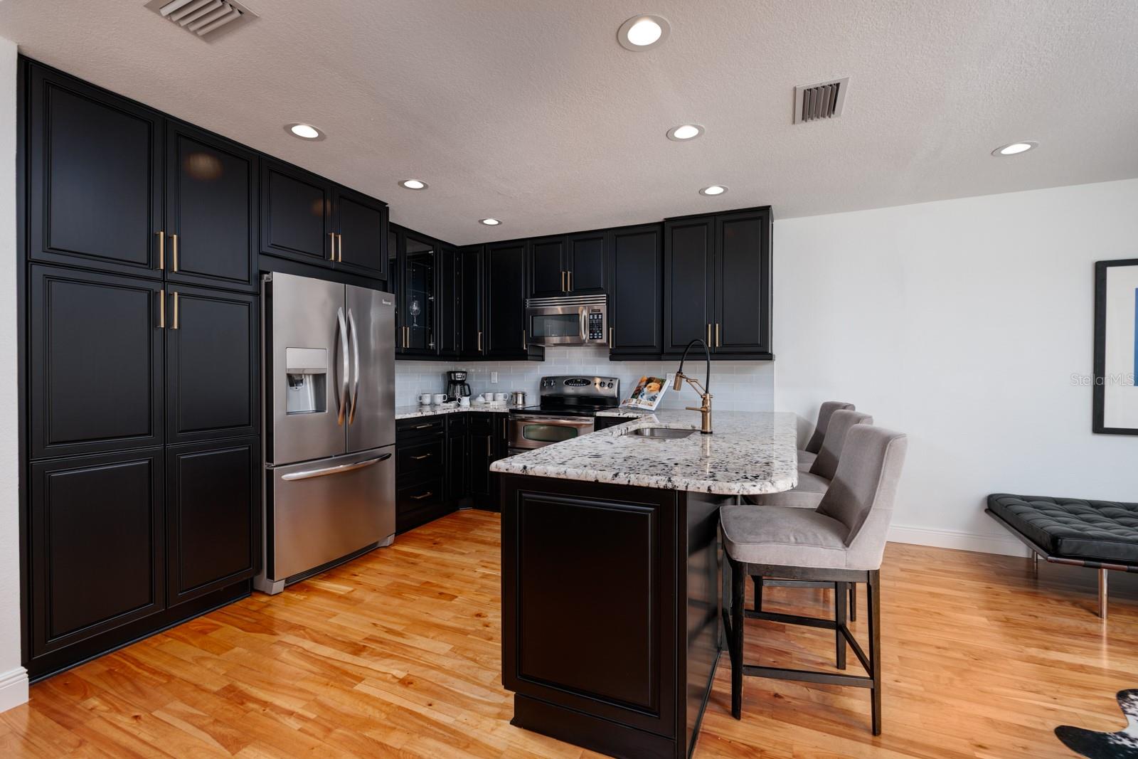 Sleek Kitchen Remodel with Casual Dining Center Island Seating and Large Pantry.