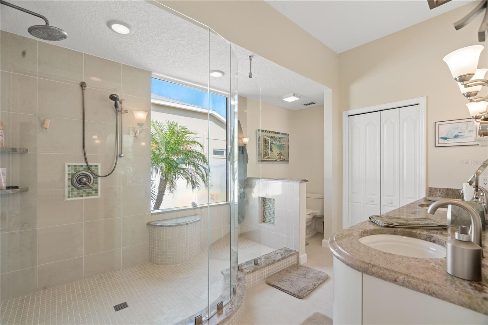 The primary bathroom has been exquisitely remodeled with wall to wall tiles and custom glass