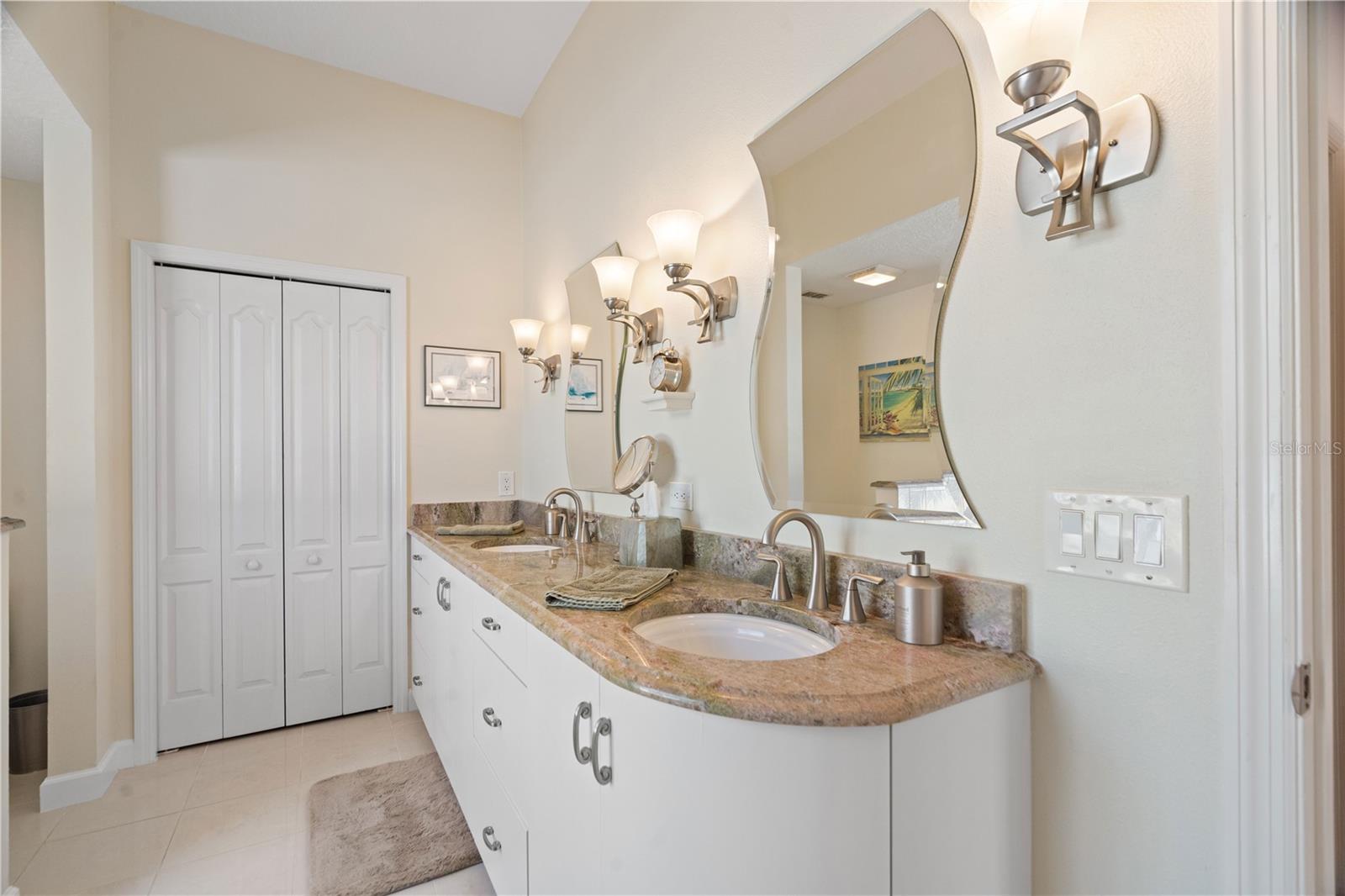 LIght fixtures above the double vanity have been replaced. Granite countertop with double vanity is a neutral color.