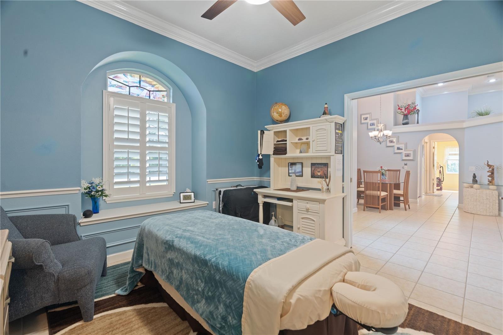 Notice the decorative archway at the window that houses a window seat. Plantation shutter provides privacy when needed and the transom window brings in extra sunshine