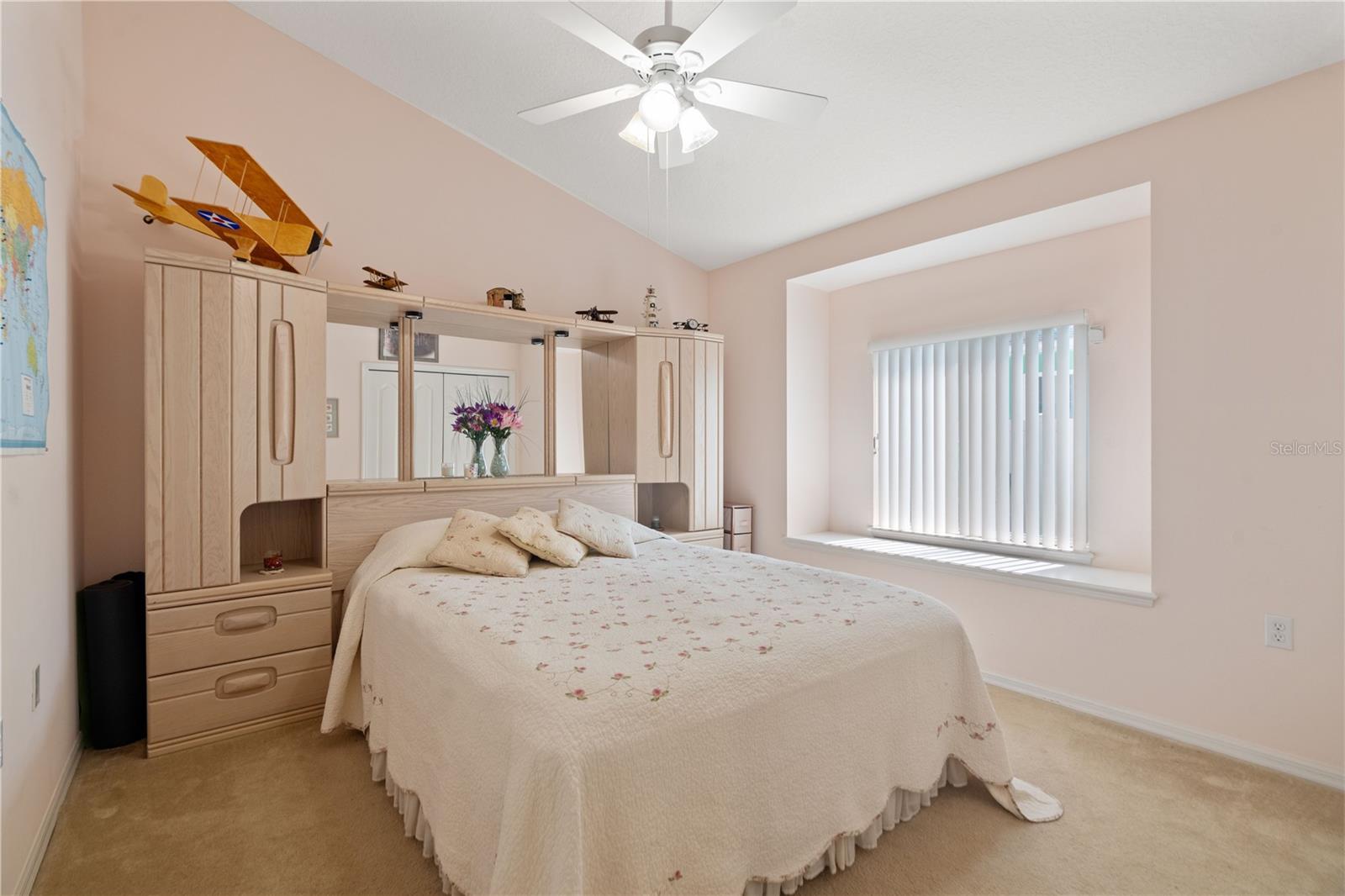 Bedroom 1 has carpeting and a ceiling fan with light kit.