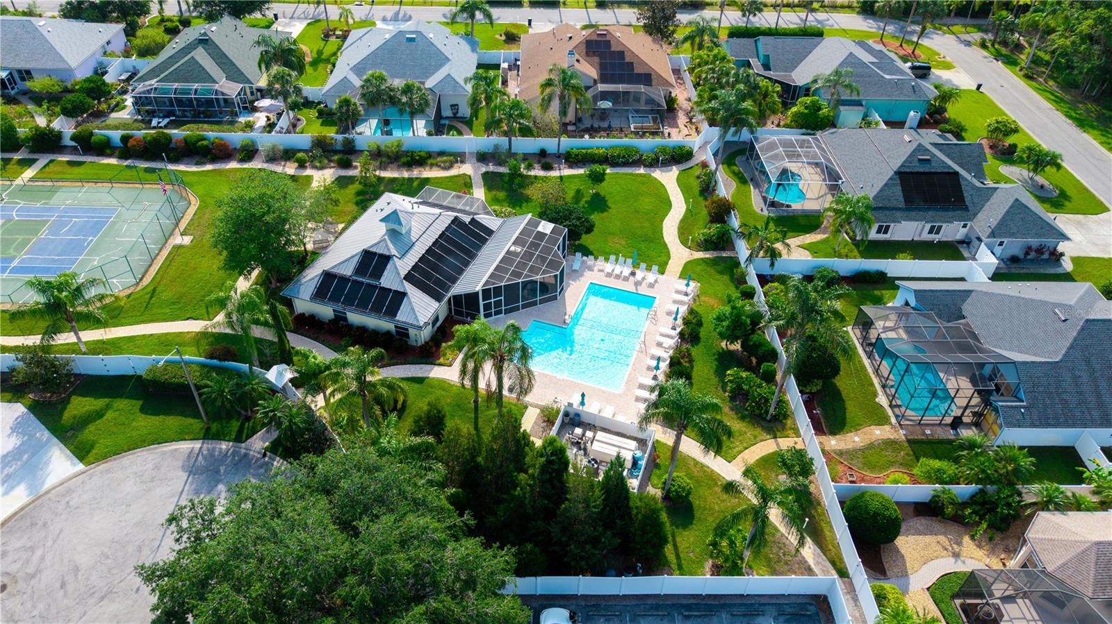 Aerial view of the community tennis court, club house and pool area. Notice the solar panels on the roof that heat the pool.