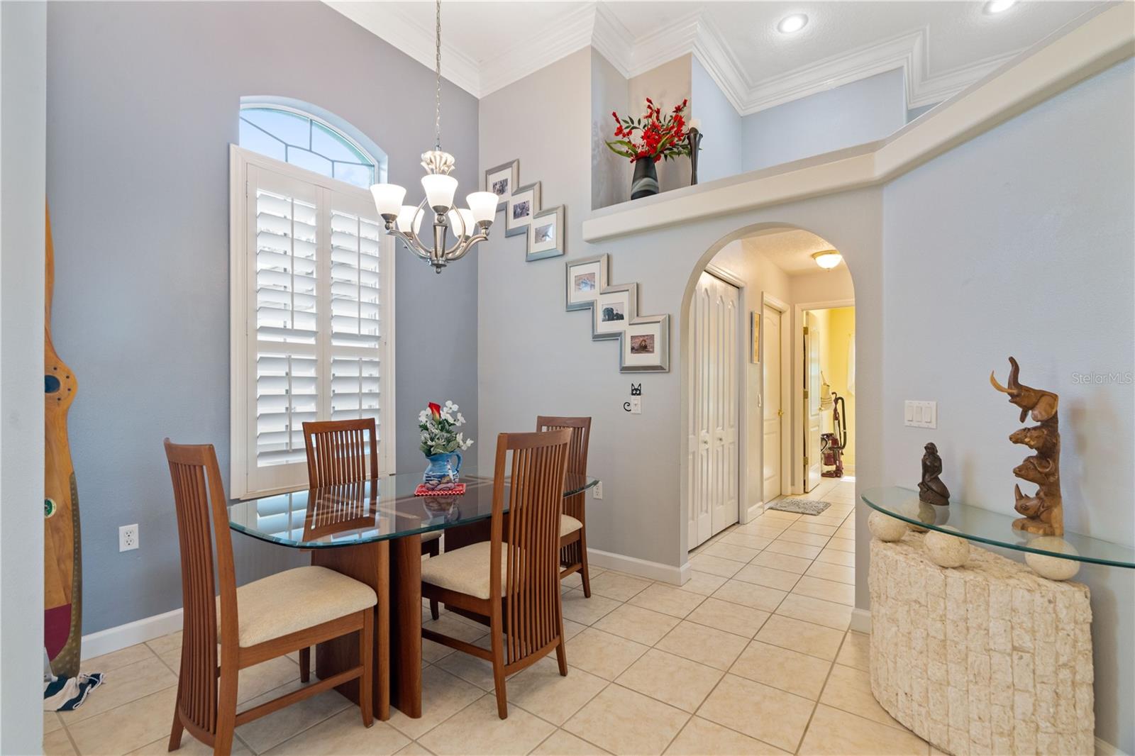 Plantation shutters and a transom window at the dining nook. Look at the intricate details at the ceiling with the crown molding.
