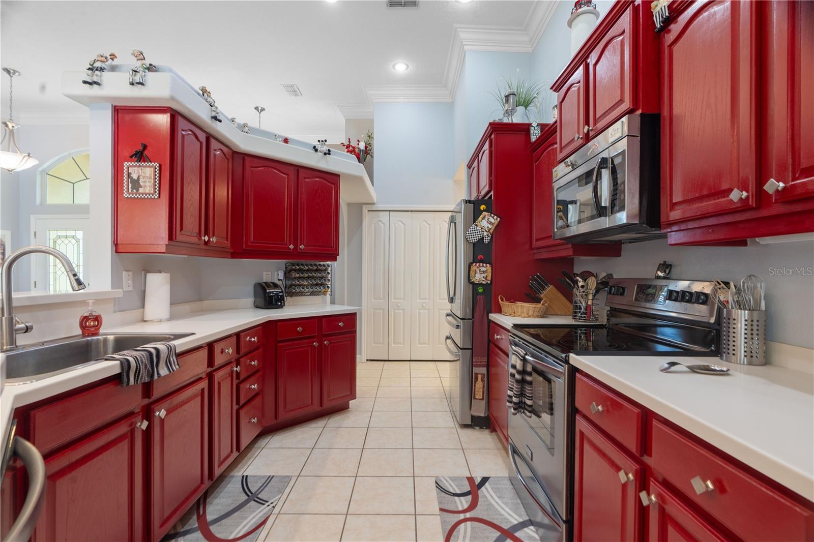 Stainless appliances adorn the kitchen. Decorative drywall shelving with rounded corner bead are featured about the kitchen cabinet separating the dining room from the kitchen