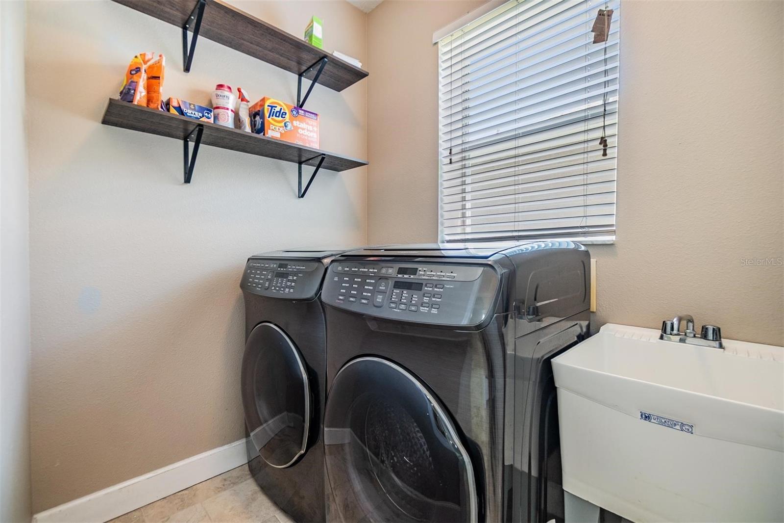 Walk in laundry room with utility sink