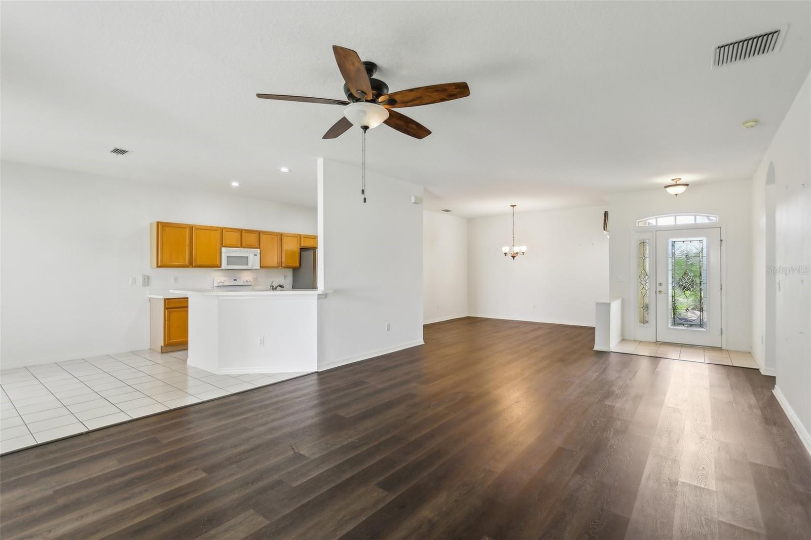 VIEW OF ENTRY, KITCHEN AND DINING ROOM FROM THE FAMILY ROOM