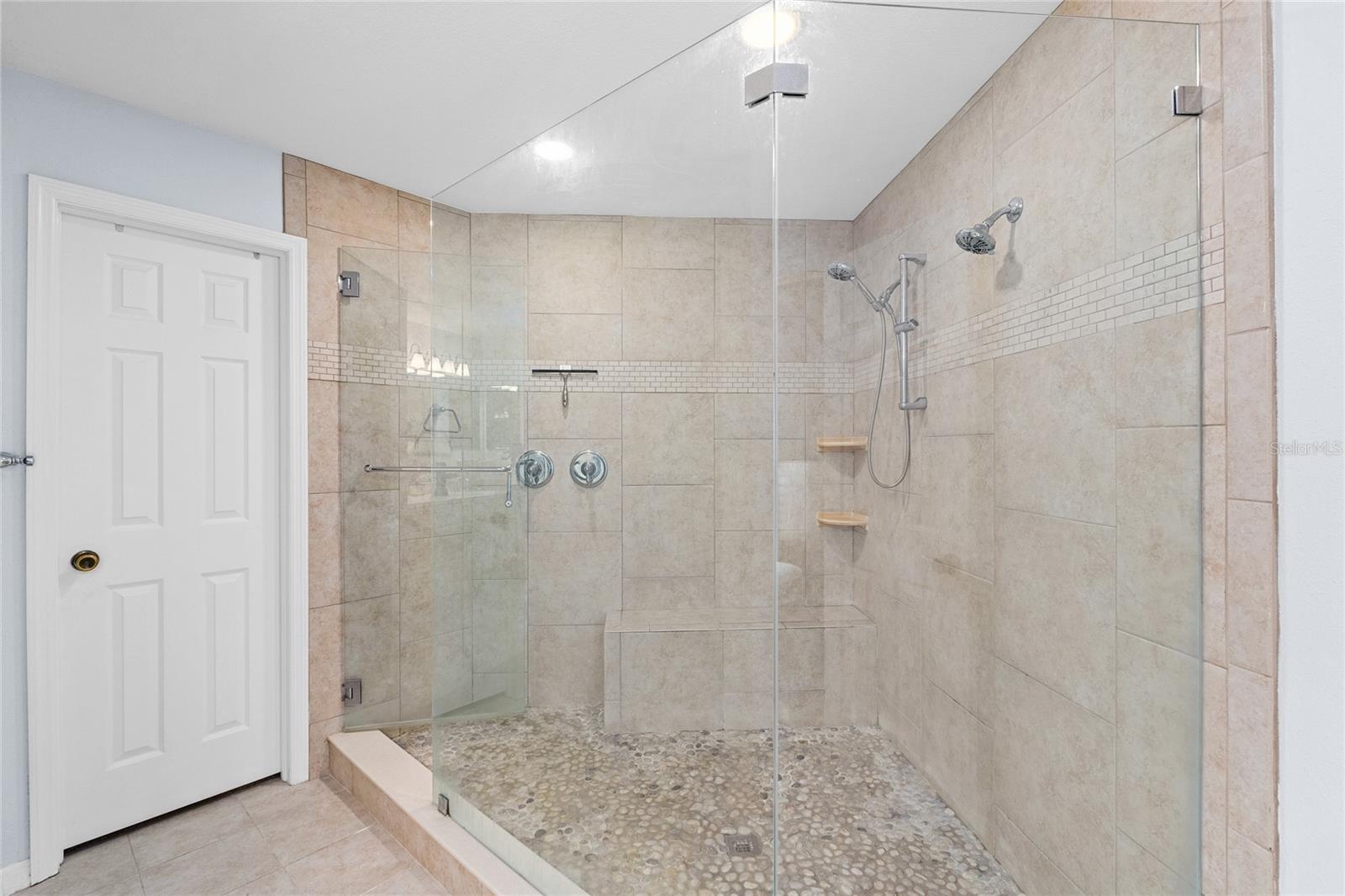 Primary Bathroom has a Huge shower with floor to ceiling tile