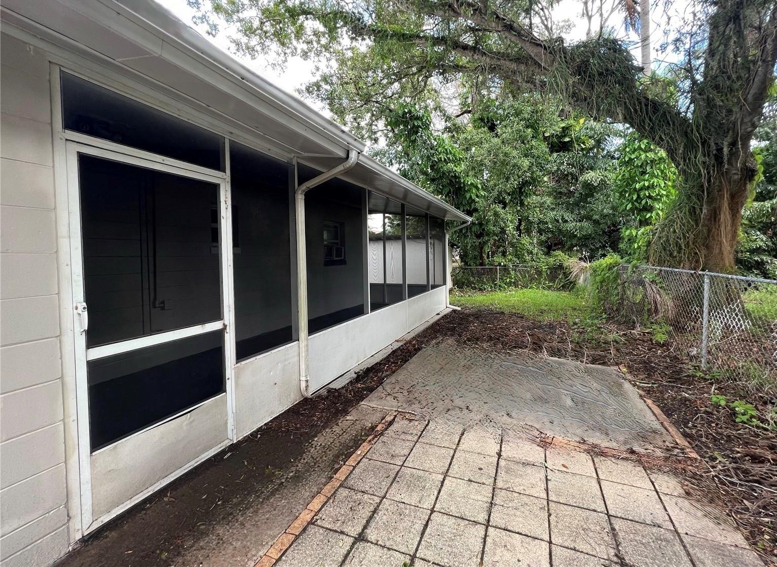 Large screened porch on the side of the home faces a shady patio.